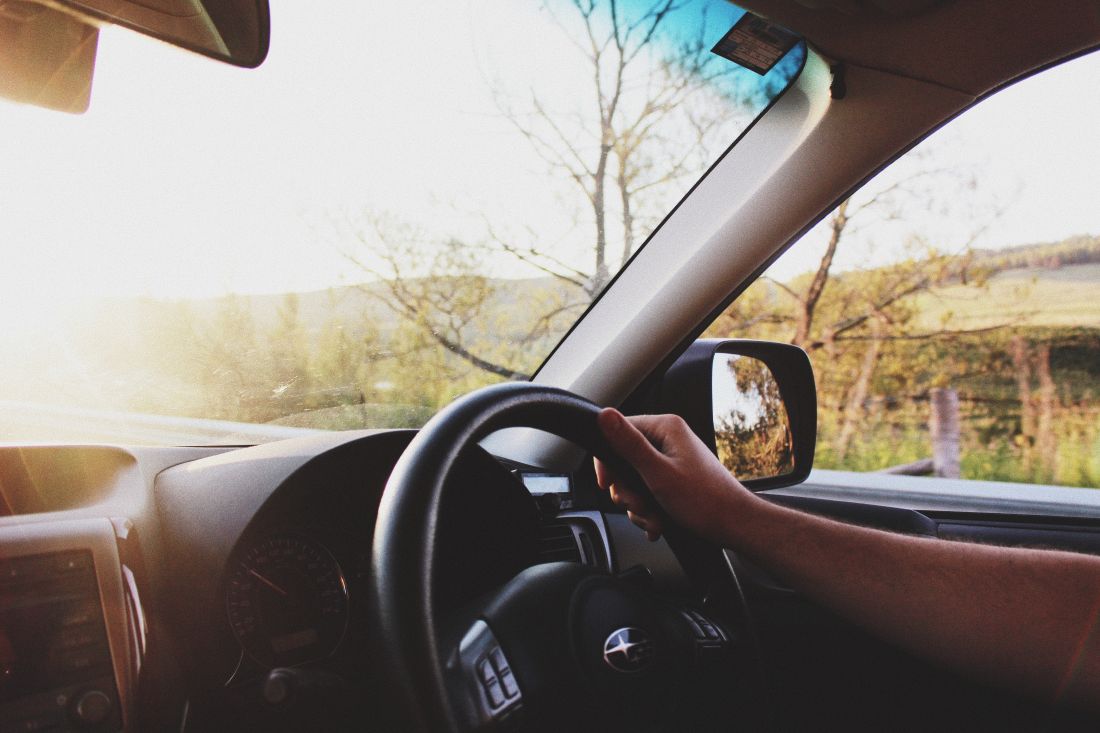 Inside View of a Person Driving a Subaru With Their Right Hand